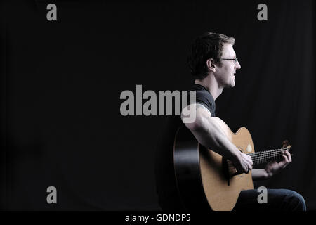 Touche Bas shot of mid adult man playing guitar Banque D'Images