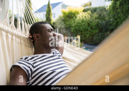Jeune homme de vous coucher sur un hamac de jardin Banque D'Images
