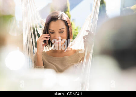 Happy young woman relaxing on jardin Hamac Banque D'Images