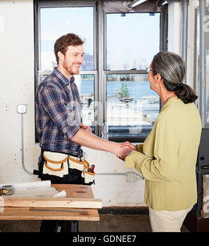 Carpenter se serrer la main avec le client Banque D'Images
