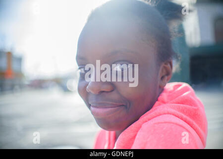 Portrait of teenage girl wearing hoody rose sur trottoir urbain Banque D'Images