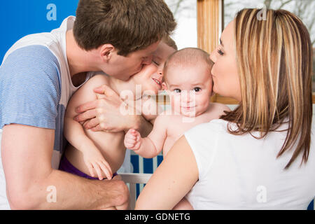 Closeup portrait of young parents kissing beau fils nouveau-né Banque D'Images