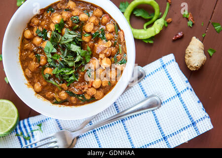 Vu de haut un plat indien, chana masala, sur une table en bois rustique, cuits dans la cuisine Banque D'Images