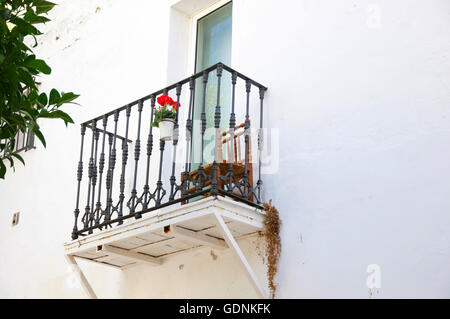 Visualiser jusqu'à rose rouge et une chaise sur un balcon. Banque D'Images