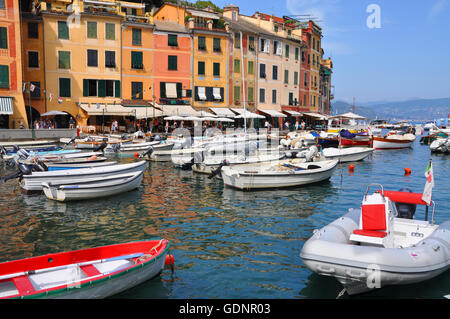 Portofino Harbour : petits bateaux de pêche flottant sur l'eau colorée dans le célèbre port italien Banque D'Images