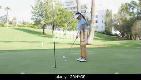 Golfeur femme la queue pour un putt Banque D'Images