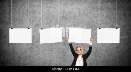 Businesswoman holding blank poster sur la tête. Trois cases vides poster accroché sur une corde Banque D'Images