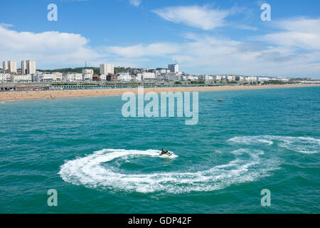 Un jet ski juste à côté du Palace Pier de Brighton sur la côte sud de l'Angleterre. Banque D'Images