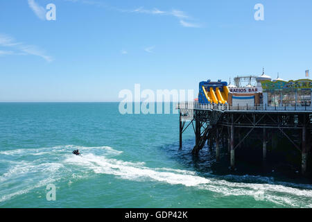 Un jet ski juste à côté du Palace Pier de Brighton sur la côte sud de l'Angleterre. Banque D'Images