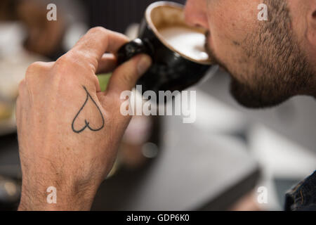 Portrait de tattooed man drinking coffee Banque D'Images
