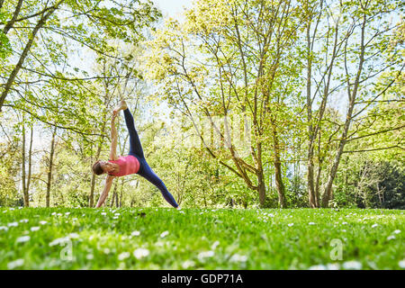 Femme bras et jambe soulevée in yoga position Banque D'Images