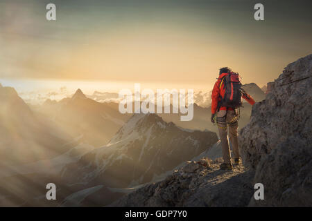 Climber regardant une gamme de montagne au coucher du soleil, Alpes, Canton du Valais, Suisse Banque D'Images