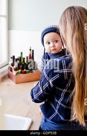 Woman wearing Knit hat fils bébé dans la cuisine Banque D'Images