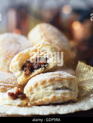 Pâte feuilletée tartes hachées, saupoudrés de sucre glace, sur plaque vintage, noël fairy lights in background Banque D'Images