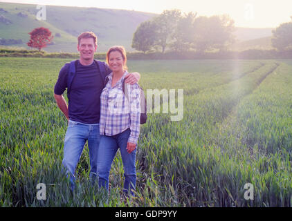 Couple in field looking at camera smiling Banque D'Images