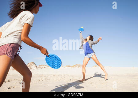 Les femmes sur la plage à jouer au tennis Banque D'Images