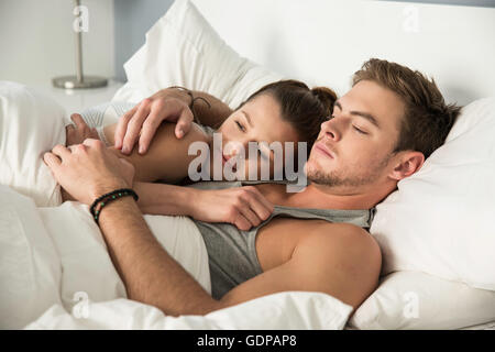 Young couple Lying in Bed hugging Banque D'Images