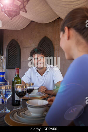Jeune couple enjoying meal smiling, Marrakech, Maroc Banque D'Images