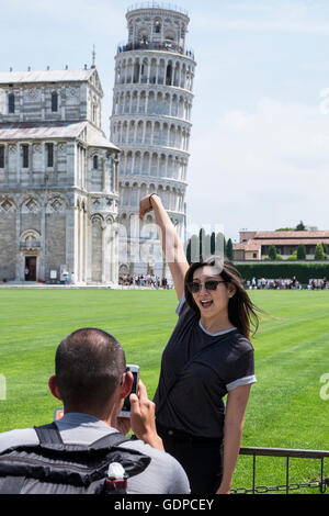 Les touristes à la tour penchée de Pise posant dans des poses absurdes pour les photographies, Pise, Toscane, Italie Banque D'Images