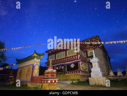 Aube peint le ciel en bleu profond au-dessus d'un temple tibétain dans l'ouest de la Chine. La Voie lactée est encore visible dans le sout Banque D'Images