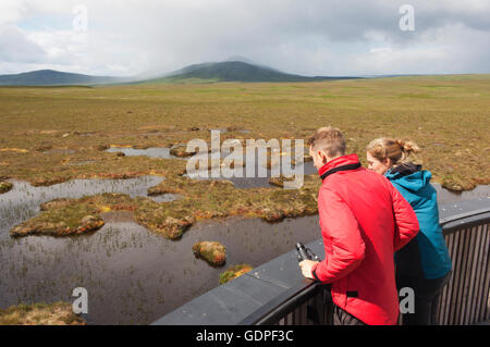 Jeune couple à la tourbière de piscines sur la tour d'observation sur la RSPB Dubh Lochan Trail, Forsinard, Sutherland, Scotland. Banque D'Images