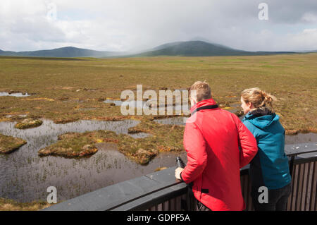 Jeune couple à la tourbière de piscines sur la tour d'observation sur la RSPB Dubh Lochan Trail, Forsinard, Sutherland, Scotland. Banque D'Images