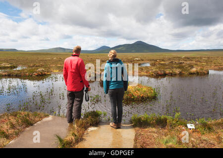 Jeune couple à la découverte des piscines des tourbières sur la RSPB Dubh Lochan Piste à Forsinard, Sutherland, Scotland. Banque D'Images