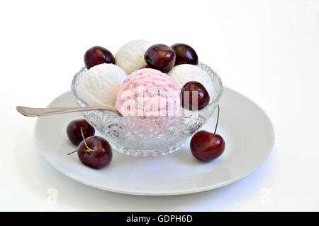 Crème à la cerise et crème glacée à la vanille avec des cerises fraîches dans un bol, Close up, macro, fond blanc Banque D'Images