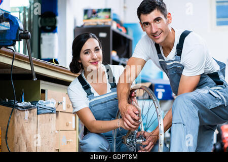 La femme et l'homme comme la mécanique vélo à l'atelier Banque D'Images