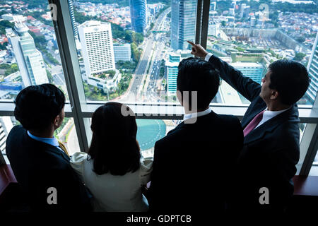 Groupe d'immobilier d'Asie business people looking at city skyline de skyscraper office building Banque D'Images