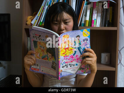 Transfuge de l'adolescence de la Corée du Nord la lecture d'un manga coréen livre, région de la capitale nationale, Séoul, Corée du Sud Banque D'Images