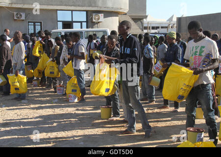 Tripoli. 21 juillet, 2016. Les migrants illégaux s'asseoir sur le quai de port de Tripoli Tripoli (Libye) le 21 juillet 2016. Quelque 137 migrants d'origine africaine ont été secourus par deux bateaux de la garde côtière en mer lorsque leur bateau a commencé naufrage au large de la côte libyenne. Credit : Hamza Turkia/Xinhua/Alamy Live News Banque D'Images