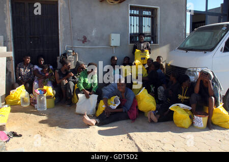 Tripoli. 21 juillet, 2016. Les migrants illégaux s'asseoir sur le quai de port de Tripoli Tripoli (Libye) le 21 juillet 2016. Quelque 137 migrants d'origine africaine ont été secourus par deux bateaux de la garde côtière en mer lorsque leur bateau a commencé naufrage au large de la côte libyenne. Credit : Hamza Turkia/Xinhua/Alamy Live News Banque D'Images