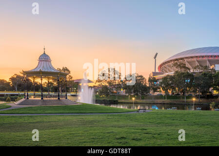 Coucher du soleil dans la Cité des rives avec la rotonde ornée Elder Park flanquée de l'Adelaide Oval, récemment modernisé. Banque D'Images