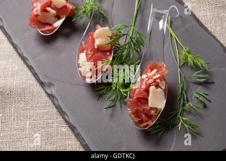 Apéritif avec carpaccio de viande, et le parmesan servi sur une cuillère Banque D'Images