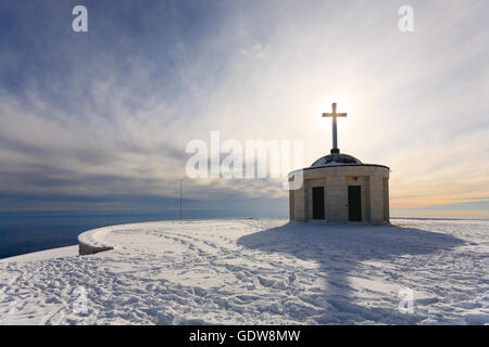 Cristian traverser une petite église avec soleil en contre-jour. Panorama d'hiver italien Banque D'Images