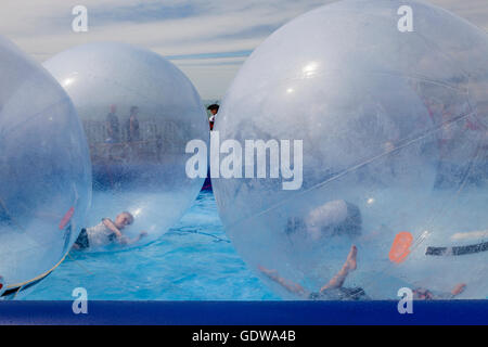 Les enfants "zorbing" sur l'eau, jetée d'Hastings Hastings, Sussex, UK Banque D'Images