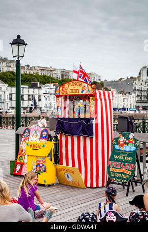 Les gens regardent un traditionnel Punch and Judy Show sur Hastings Pier, Hastings, Sussex, UK Banque D'Images