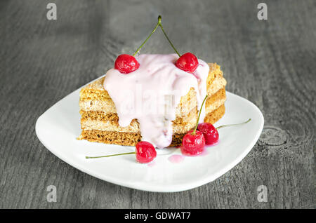 Avec cerise sur le gâteau et la plaque de fond de bois Banque D'Images