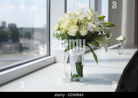 Beau mariage bouquet dans un vase de verre. Des fleurs sur le rebord blanc. Boutonnière dans un petit vase. Banque D'Images