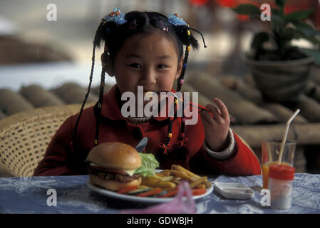 Une fille avec un hanburger dans un restaurant dans la ville de Yangshou près de la ville de Guilin dans la province de Guangxi en chine en Banque D'Images