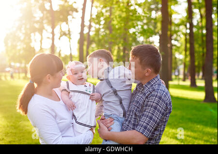 Heureux jeune famille avec enfants promenades dans le parc d'été Banque D'Images