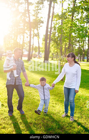 Heureux jeune famille avec enfants promenades dans le parc d'été Banque D'Images