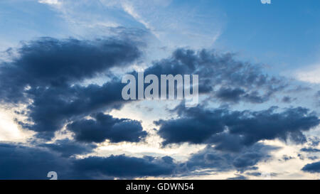 Des nuages sombres sur fond de ciel bleu Banque D'Images