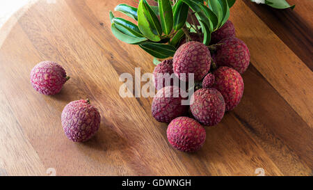 Le litchi avec des feuilles sur une planche en bois, still life Banque D'Images