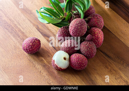 Le litchi avec des feuilles sur une planche en bois, still life Banque D'Images