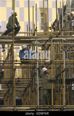 Les travailleurs se tiennent sur scaffoldiing sur un site de construction Banque D'Images