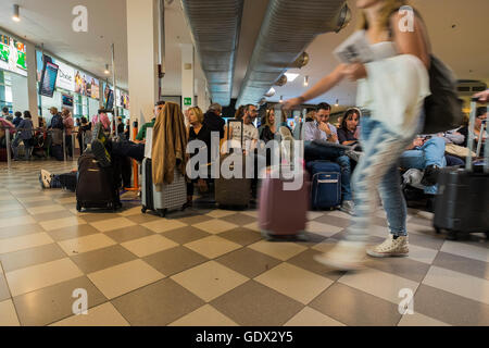 Passagers en salle d'embarquement à l'aéroport Galileo Galilei en attente de leur vol, Pise, Toscane, Italie Banque D'Images