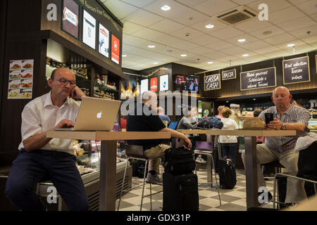 Les passagers sur les ordinateurs portables et les téléphones mobiles dans le café de la salle des départs de l'aéroport Galileo Galilei de Pise, Toscane,, je Banque D'Images