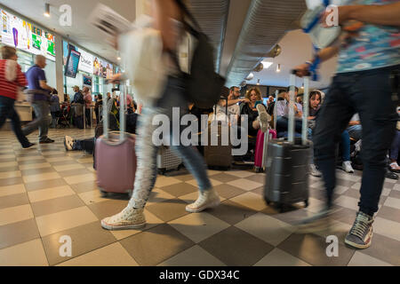 Passagers en salle d'embarquement à l'aéroport Galileo Galilei en attente de leur vol, Pise, Toscane, Italie Banque D'Images